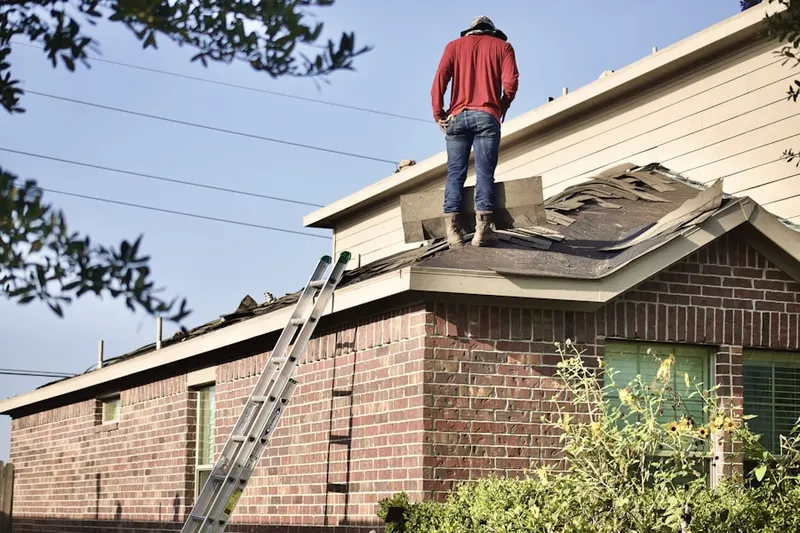 Professional roofer working on a residential roof in Buffalo Manor East